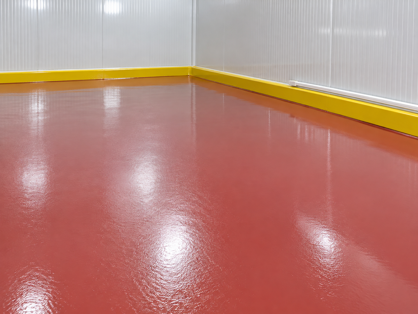 Cámara frigorífica con suelo rojo brillante y zócalo amarillo